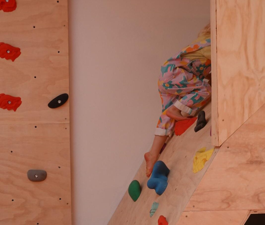 Kind klimt op speel klimmuur